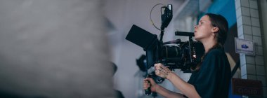 Görüntü yönetmeni elinde kamerayla sette. Bir film, ticari ya da televizyon dizisi çekmek için çalışan profesyonel bir videograf. İçerideki çekim süreci, stüdyo.