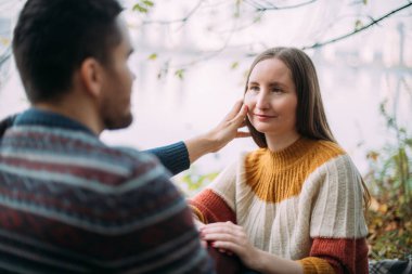 Romantik bir randevu, doğa yürüyüşü. Genç aşıklar sonbaharın başlarında gölde beraberler. Erkek ve kadın sarı sonbahar yaprakları içinde suyun kenarında yürüyorlar.