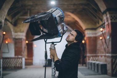Işıklandırma ekipmanlı aydınlatma cihazları sette. Film çekmek, reklam yapmak, TV dizisi için ışıklandırma. Modern fotoğrafçılık tekniği.