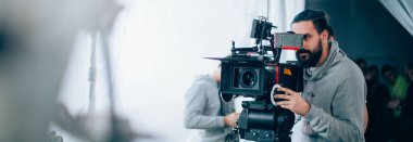 Görüntü yönetmeni elinde kamerayla sette. Bir film, ticari ya da televizyon dizisi çekmek için çalışan profesyonel bir videograf. İçerideki çekim süreci, stüdyo.
