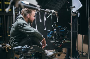 Görüntü yönetmeni elinde kamerayla sette. Bir film, ticari ya da televizyon dizisi çekmek için çalışan profesyonel bir videograf. İçerideki çekim süreci, stüdyo.