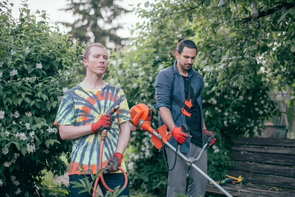 Dois Homens Estão Trabalhar Jardim Eles Cortam Grama Com Cortador — Fotografia de Stock