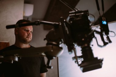 Görüntü yönetmeni elinde kamerayla sette. Bir film, ticari ya da televizyon dizisi çekmek için çalışan profesyonel bir videograf. İçerideki çekim süreci, stüdyo.