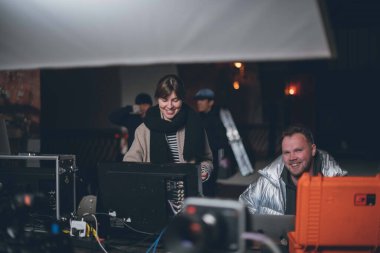 Yönetmen sette çalışıyor. Yönetmen, bir film, reklam ya da televizyon dizisi çekerken bir grupla ya da bir playback ile çalışır. Atış vardiyası, ekipman ve grup. Modern fotoğrafçılık tekniği.