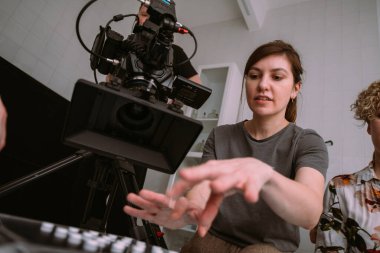 Görüntü yönetmeni elinde kamerayla sette. Bir film, ticari ya da televizyon dizisi çekmek için çalışan profesyonel bir videograf. İçerideki çekim süreci, stüdyo.