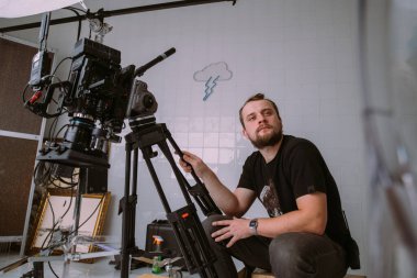 Görüntü yönetmeni elinde kamerayla sette. Bir film, ticari ya da televizyon dizisi çekmek için çalışan profesyonel bir videograf. İçerideki çekim süreci, stüdyo.