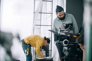 Görüntü yönetmeni elinde kamerayla sette. Bir film, ticari ya da televizyon dizisi çekmek için çalışan profesyonel bir videograf. İçerideki çekim süreci, stüdyo.