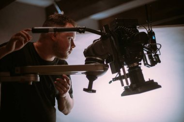 Görüntü yönetmeni elinde kamerayla sette. Bir film, ticari ya da televizyon dizisi çekmek için çalışan profesyonel bir videograf. İçerideki çekim süreci, stüdyo.