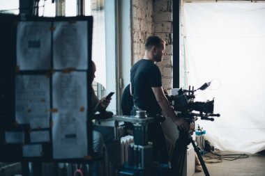 Görüntü yönetmeni elinde kamerayla sette. Bir film, ticari ya da televizyon dizisi çekmek için çalışan profesyonel bir videograf. İçerideki çekim süreci, stüdyo.