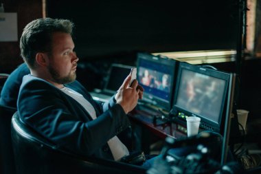 Yönetmen sette çalışıyor. Yönetmen, bir film, reklam ya da televizyon dizisi çekerken bir grupla ya da bir playback ile çalışır. Atış vardiyası, ekipman ve grup. Modern fotoğrafçılık tekniği.