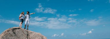 Okyanusun destansı manzarasına sahip bir çift kayanın üzerinde duruyor. Popüler bir turizm merkezi. Sevgililer tropik bölgelerde tatildeler. Tropiklerde balayı.