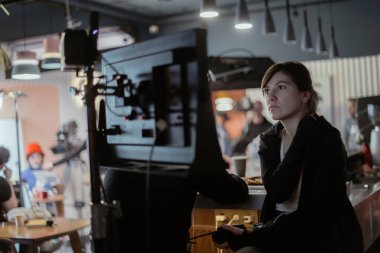 Yönetmen sette çalışıyor. Yönetmen, bir film, reklam ya da televizyon dizisi çekerken bir grupla ya da bir playback ile çalışır. Atış vardiyası, ekipman ve grup. Modern fotoğrafçılık tekniği.