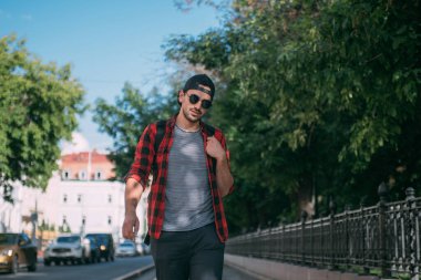 Bir erkek turist sırt çantasıyla sokaklarda yürüyor. Genç bir adam Avrupa sokaklarında tek başına yürüyor.