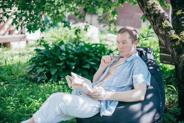 Homem Está Descansando Lendo Otomano Jardim Dia Folga Relaxamento Jovem — Fotografia de Stock