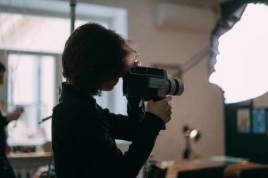 Çekim sırasında elinde kamera olan bir kadın görüntü yönetmeni. Bir filmin modern çekim süreci, sette reklam..