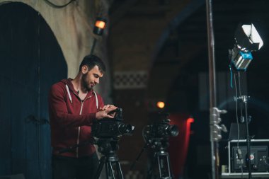 Görüntü yönetmeni elinde kamerayla sette. Bir film, ticari ya da televizyon dizisi çekmek için çalışan profesyonel bir videograf. İçerideki çekim süreci, stüdyo.