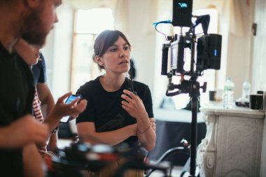 Yönetmen sette çalışıyor. Yönetmen, bir film, reklam ya da televizyon dizisi çekerken bir grupla ya da bir playback ile çalışır. Atış vardiyası, ekipman ve grup. Modern fotoğrafçılık tekniği.