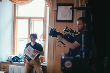 Görüntü yönetmeni elinde kamerayla sette. Bir film, ticari ya da televizyon dizisi çekmek için çalışan profesyonel bir videograf. İçerideki çekim süreci, stüdyo.