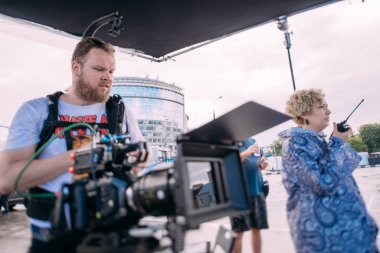 Görüntü yönetmeni elinde kamerayla sette. Bir film, ticari ya da televizyon dizisi çekmek için çalışan profesyonel bir videograf. Sokakta, konumda çekim işlemi.