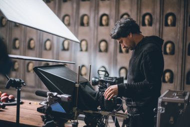 Görüntü yönetmeni elinde kamerayla sette. Bir film, ticari ya da televizyon dizisi çekmek için çalışan profesyonel bir videograf. İçerideki çekim süreci, stüdyo.