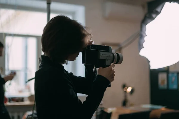 Female director of photography with a film camera on the shooting. Modern filming process of a film, advertising on the set.