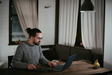 Bir adam akşamları iş yerindeki tabletine resim çizer. Genç bir sanatçı ve tasarımcı gece geç saatlere kadar oturma odasında bir masada çalışır..