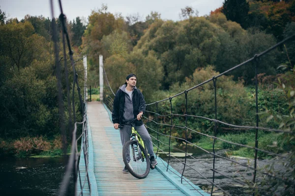 Мужчина Велосипеде Осенью Мосту Молодой Парень Велосипедом Большом Подвесной Мосту — стоковое фото