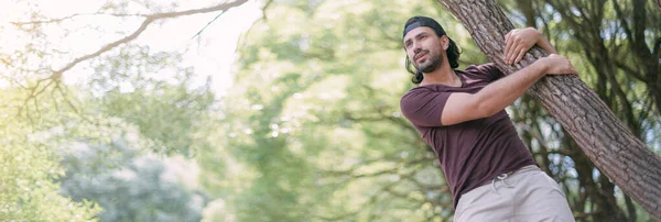 Ein Junger Mann Sitzt Auf Einem Baum Park Schöner Typ — Stockfoto