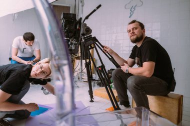 Görüntü yönetmeni elinde kamerayla sette. Bir film, ticari ya da televizyon dizisi çekmek için çalışan profesyonel bir videograf. İçerideki çekim süreci, stüdyo.