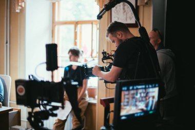 Görüntü yönetmeni elinde kamerayla sette. Bir film, ticari ya da televizyon dizisi çekmek için çalışan profesyonel bir videograf. İçerideki çekim süreci, stüdyo.