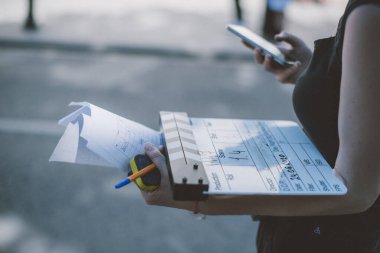 Sette klaket tahtası olan yardımcı yönetmen. Bir film, reklam, televizyon dizisi çekmek için havai fişek yakın çekim. Modern fotoğrafçılık tekniği.