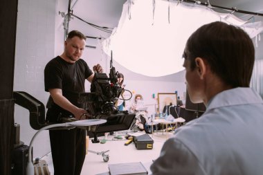 Görüntü yönetmeni elinde kamerayla sette. Bir film, ticari ya da televizyon dizisi çekmek için çalışan profesyonel bir videograf. İçerideki çekim süreci, stüdyo.