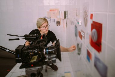 Görüntü yönetmeni elinde kamerayla sette. Bir film, ticari ya da televizyon dizisi çekmek için çalışan profesyonel bir videograf. İçerideki çekim süreci, stüdyo.