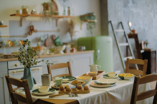 薄緑色の北欧素朴なスタイルのモダンなキッチン セラミック料理の朝食付きのキッチンとダイニングテーブルの詳細 — ストック写真