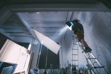 Işıklandırma ekipmanlı aydınlatma cihazları sette. Film çekmek, reklam yapmak, TV dizisi için ışıklandırma. Modern fotoğrafçılık tekniği.