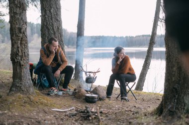 Evli bir çift gölün kıyısındaki bir kamp ateşinde çadır kurarak yemek hazırlıyor. Ormanda şenlik ateşiyle yürüyüş kampı. Bir erkek ve bir kadın çadırın yanındaki ateşin yanında sessizliğin tadını çıkarırlar.