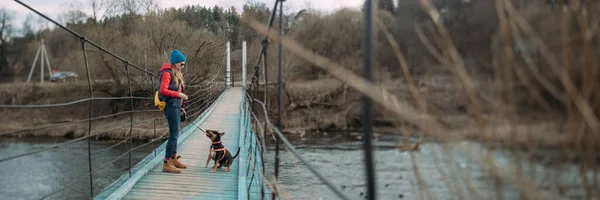 Una Mujer Camina Con Perro Sobre Río Puente Colgante Chica —  Fotos de Stock