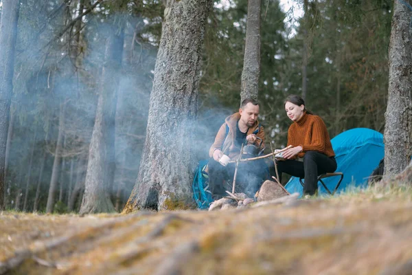 Evli bir çift gölün kıyısındaki bir kamp ateşinde çadır kurarak yemek hazırlıyor. Ormanda şenlik ateşiyle yürüyüş kampı. Bir erkek ve bir kadın çadırın yanındaki ateşin yanında sessizliğin tadını çıkarırlar.