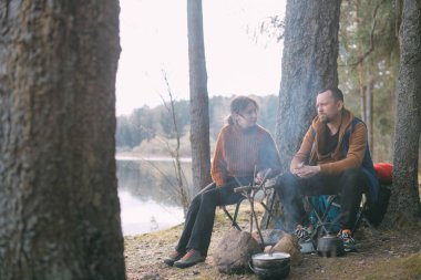 Evli bir çift gölün kıyısındaki bir kamp ateşinde çadır kurarak yemek hazırlıyor. Ormanda şenlik ateşiyle yürüyüş kampı. Bir erkek ve bir kadın çadırın yanındaki ateşin yanında sessizliğin tadını çıkarırlar.