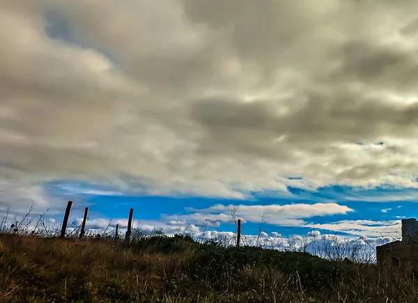 Paesaggio Campo Con Terraferma Alcuni Pali Legno Con Cielo Blu — Foto Stock