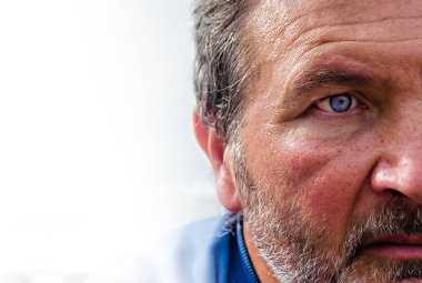 Yarısı mavi gözlü bir adamın önünde, açık beyaz bir arkaplanda.