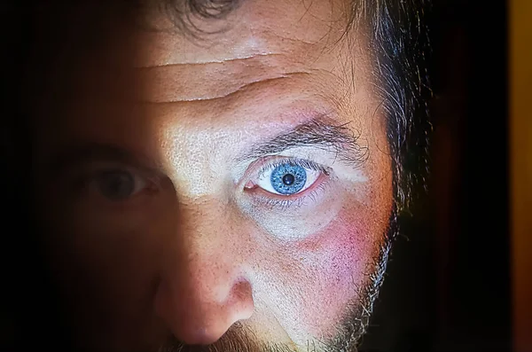 Twarz Człowieka Niebieskimi Oczami Połowie Świetle — Zdjęcie stockowe