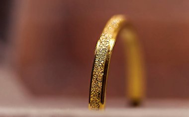 Bulanık turuncu arka plana yakın altın bir yüzük.