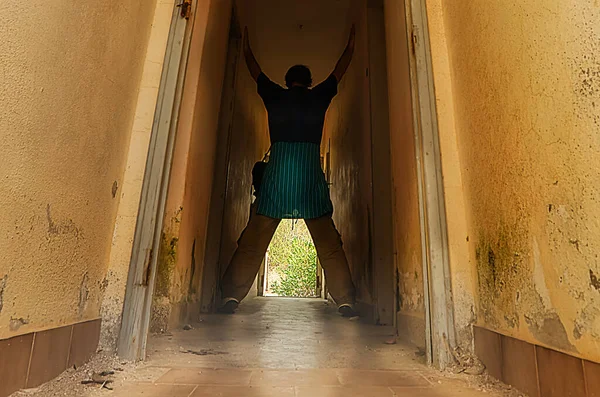 In a dark hallway in an abandoned house with a man