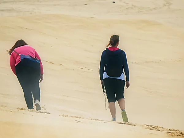 Dwie Kobiety Spacerujące Plaży Mglisty Dzień — Zdjęcie stockowe