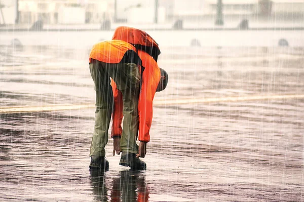 Uomo Arancione Allacciando Suoi Stivali Stringati Sotto Pioggia — Foto Stock