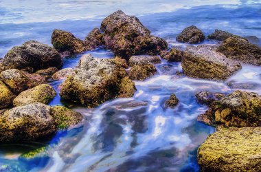 Sahilde kayalar ve ipek gibi deniz manzarası