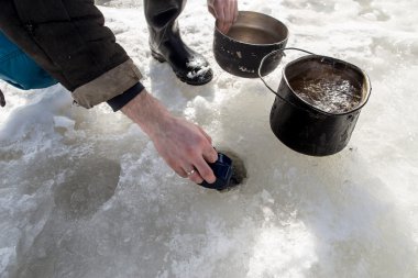 balıkçı, buzda delik su çizer. 