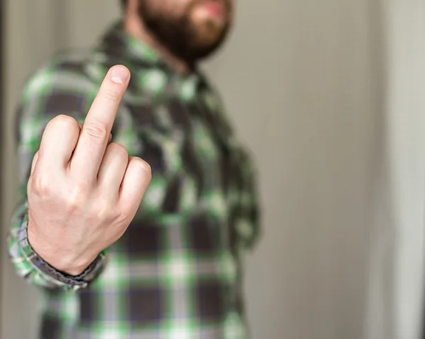 Hombre barbudo en una camisa a cuadros hizo un gesto grosero dedo medio — Foto de Stock