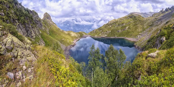 Панорамный пейзаж с озером в горах, огромные скалы и — стоковое фото